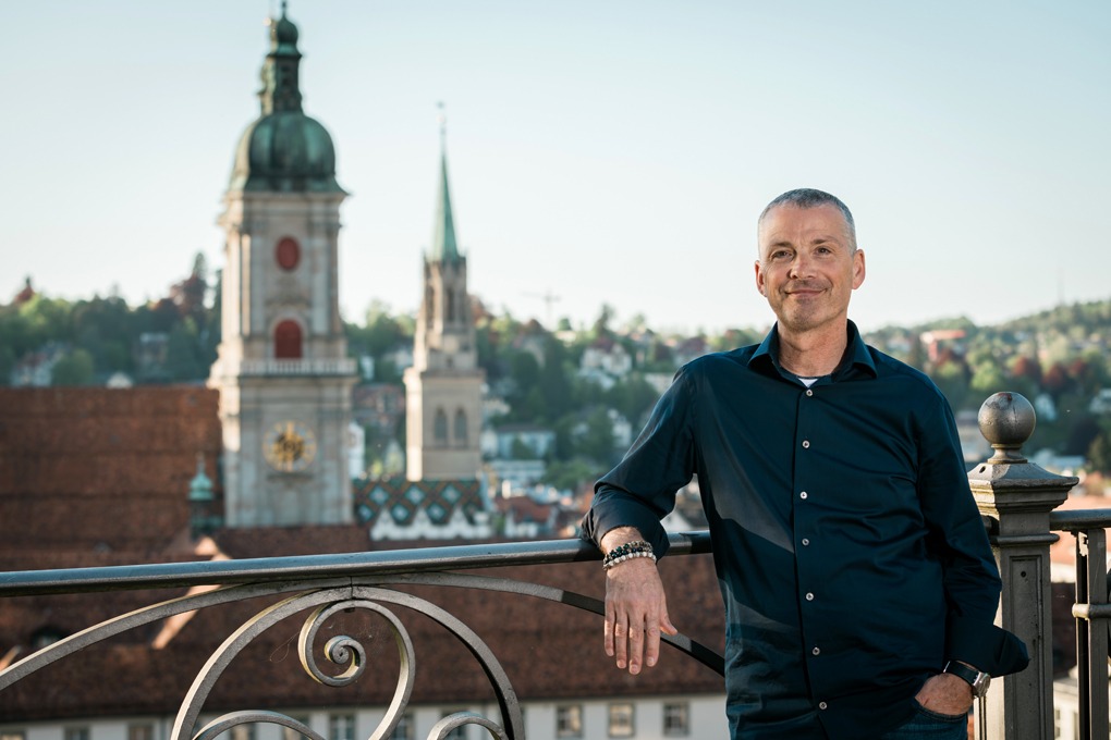 Christian Strässle auf einer Terrasse mit Blick auf die Stiftskirche St. Gallen